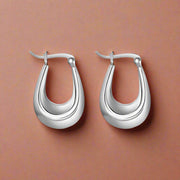A pair of silver hoop earrings on a white background